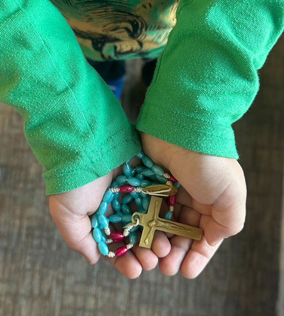 Child's hands holding a rosary