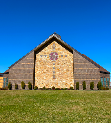 St. Thomas Aquinas in Indianola Church exterior of worship area cross with blue sky